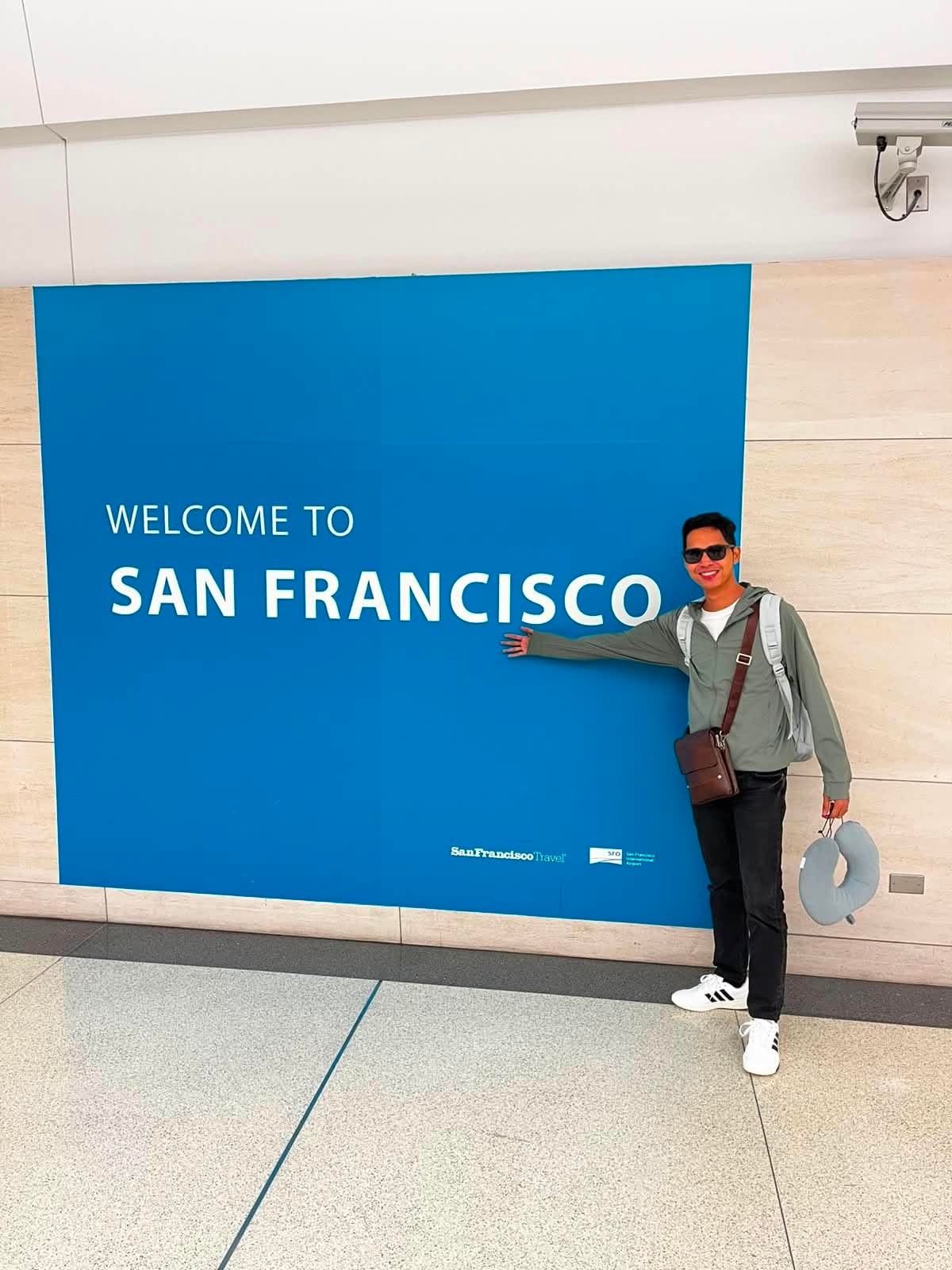 CrossBorder teacher arriving at Welcome to San Francisco airport sign